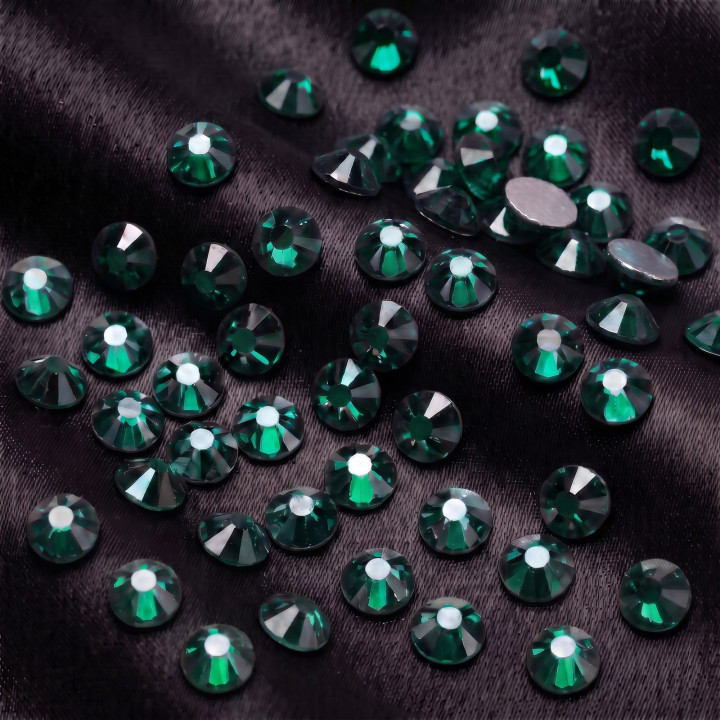 Zielone cyrkonie szklane Emerald Satin na czarnej tkaninie
